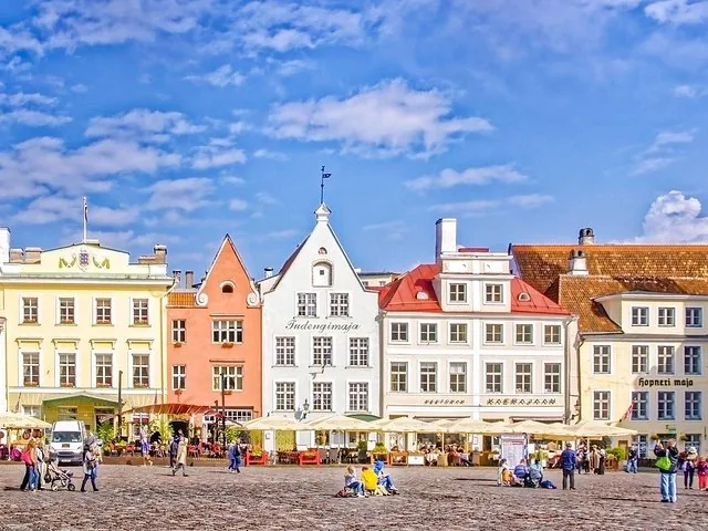 Colorful historic buildings in a town square with people.