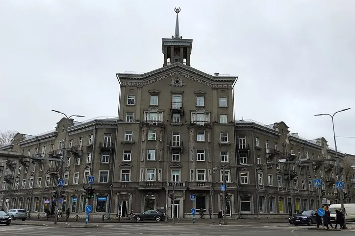 Large grey Soviet-era building with a spire and a star.